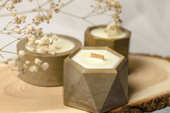 scented-candles-in-a-flowerpot-on-a-wooden-stand-soy-wax-candle-and-gypsophila-sprig